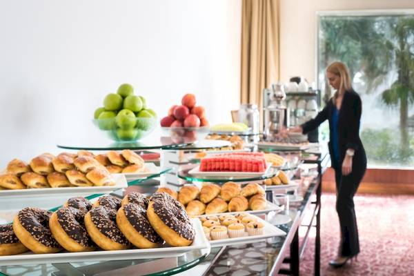 Frühstücksbuffet im Khalidiya Palace Rayhaan by Rotana mit einer Auswahl an Donuts, Brötchen und Früchten.