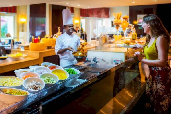 Ein Koch serviert ein Gericht an einem Buffet im Khalidiya Palace Rayhaan by Rotana Hotel.