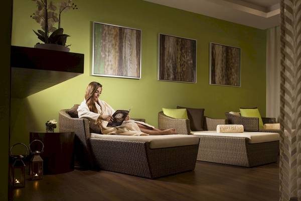 Frau im Bademantel liest ein Buch im Khalidiya Palace Rayhaan by Rotana