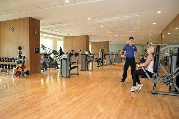 Fitnesscenter im Khalidiya Palace Rayhaan by Rotana Hotel mit gut ausgestatteten Geräten und Personal.