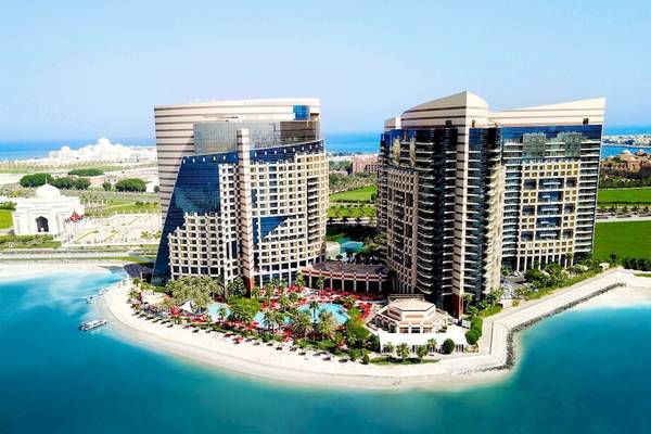 Luftaufnahme des Khalidiya Palace Rayhaan by Rotana Hotels mit zwei hohen Gebäuden und einem Swimmingpool.