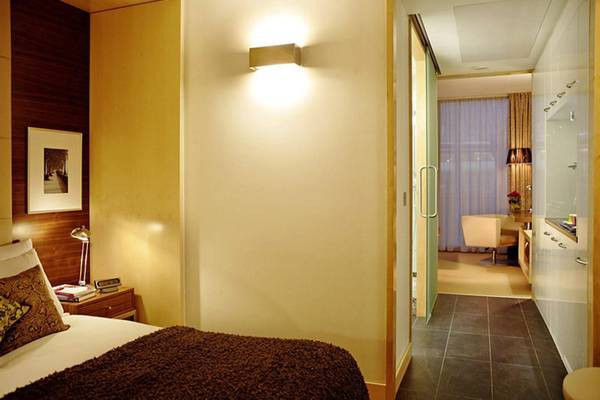 Schlafzimmer im Park Plaza County Hall London Hotel mit Bett, Kissen und Nachttisch