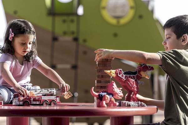 Kinder mit Spielzeug Dinos und Feuerwagen im Freizeitpark