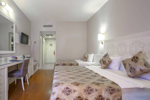Doppelzimmer im Vita Silva Hotel mit zwei Betten, Schreibtisch, Stuhl und Fernseher.