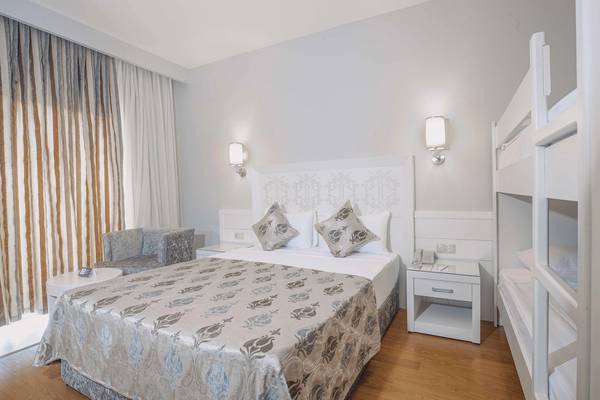 Innenansicht eines Doppelzimmers im Vita Silva Hotel mit Bett, Nachttischen und hochklappbarem Etagenbett.