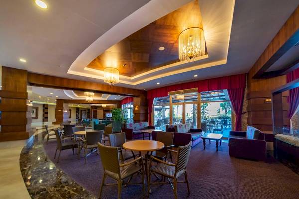 Innenbereich des Vita Silva Hotels mit Loungebereich, Tischen, Stühlen und Kronleuchtern.
