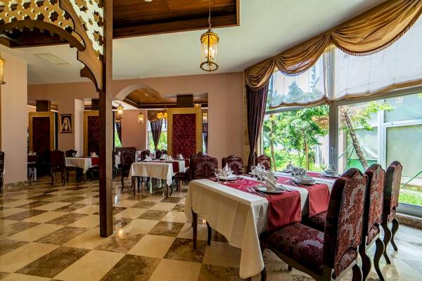 Innenansicht des Restaurants im Vita Silva Hotel mit Tisch und Stühlen, Tischdecken und Fenstern.