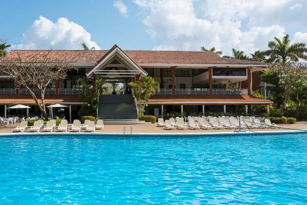 Außenbereich des Occidental Tamarindo Hotels mit großem Swimmingpool und Sonnenliegen.