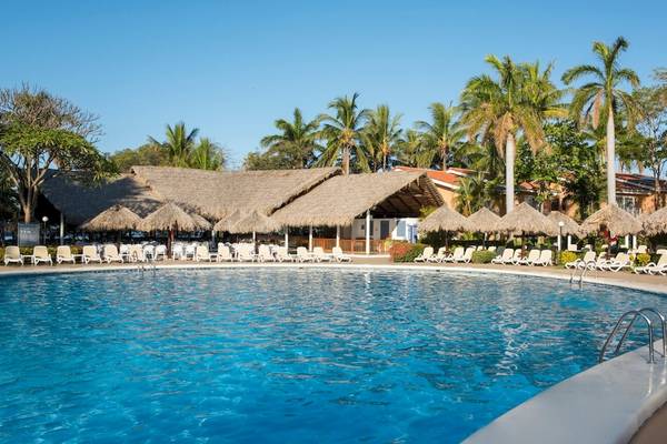 Ein Hotelpool mit vielen Liegen und Sonnenschirmen am Occidental Tamarindo.
