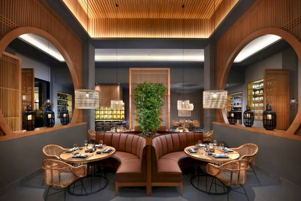 Das Interieur des Hotels 'Steigenberger Resort Ras Soma' zeigt ein Restaurant mit braunen Ledersofas, runden Tischen, hängenden Lampen und einer zentralen Pflanze.