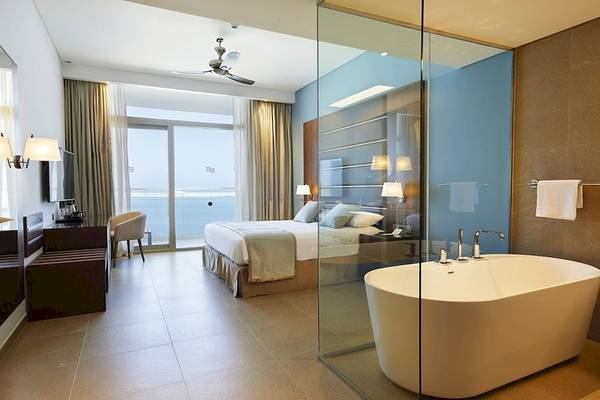 Riu Dubai Hotelzimmer mit Badezimmer und Meerblick, Bett, Badewanne und Aussicht.
