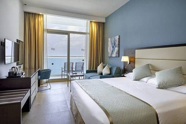 Hotelzimmer im Riu Dubai mit Meerblick, Bett, Fernseher und Möbeln.