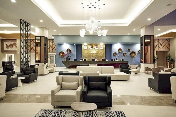 Lobby des Riu Dubai Hotels mit moderner Einrichtung und Rezeptionstresen.