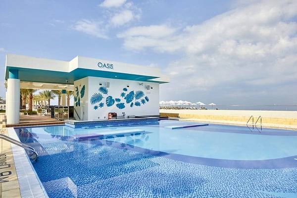 Oasis Pool vor dem Riu Dubai Hotel mit blauem Himmel und weißen Wolken