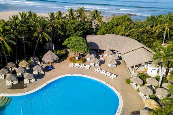 Luftaufnahme des Occidental Tamarindo Hotels mit Pool, Sonnenliegen und Sonnenschirmen