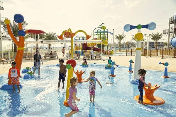 Kinder spielen im Wasserpark des Riu Dubai Hotels an einem sonnigen Tag.