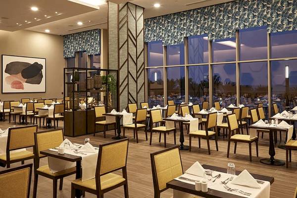 Innenansicht des Restaurants im Riu Dubai Hotel mit vollen Tischen und Stühlen.