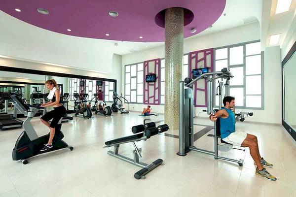 Fitnessstudio im Riu Palace Bavaro mit Geräten und Sportlern.