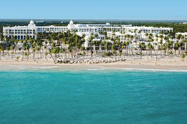 Luftaufnahme des Riu Palace Bavaro Hotels an einem Strand mit Palmen und blauem Wasser