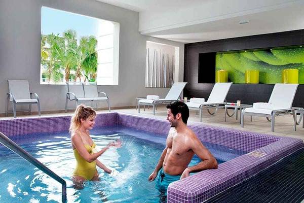 Paar im Poolbereich des Riu Palace Bavaro Hotels, das sich im Freien befindet.