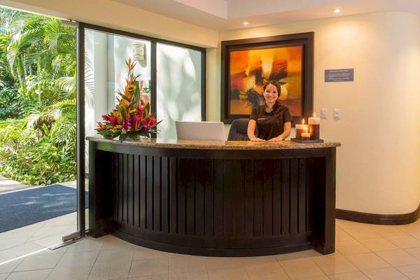 Rezeptionistin des Occidental Tamarindo Hotels lächelt vor einem großen Gemälde.