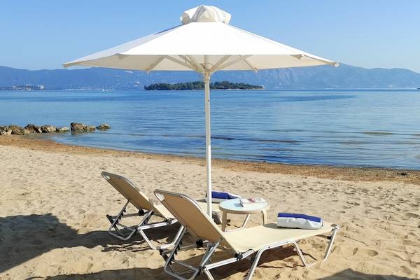 Strand mit zwei Liegen und einem Schirm im Schatten am Louis Kerkyra Blue Hotel