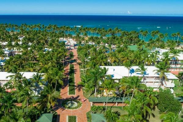 Luftaufnahme des Grand Sirenis Punta Cana Resorts mit vielen Palmen und weißen Gebäuden am Meer