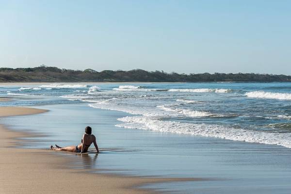 Eine Frau liegt am Strand von Occidental Tamarindo während eines sonnigen Tages.
