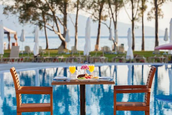 Frühstückstisch am Pool des Louis Kerkyra Blue Hotels mit Blick auf das Meer.