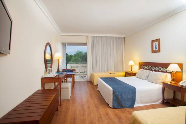 Innenansicht eines Hotelzimmers im Louis Kerkyra Blue mit zwei Betten, Schreibtisch und Balkon.