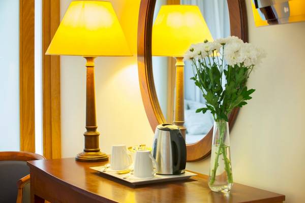 Zimmer im Louis Kerkyra Blue Hotel mit Tisch, Blumen, Kaffee und Lampen.