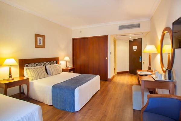 Hotelzimmer des Louis Kerkyra Blue mit Doppelbett, Nachttischen und Schreibtisch.