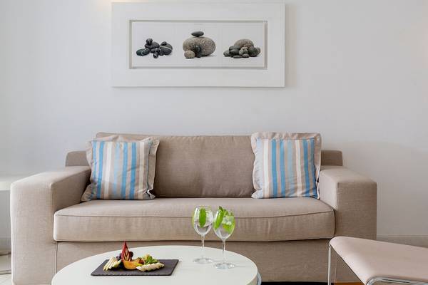 Wohnzimmer im DeLight Boutique Hotel mit Sofa, Tisch und Wandbild.