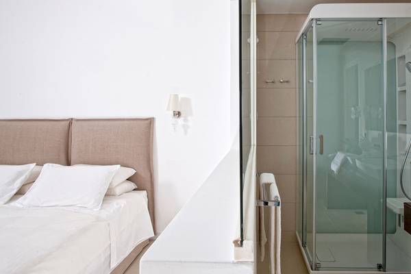 Schlafzimmer mit Doppelbett und Dusche im DeLight Boutique Hotel.