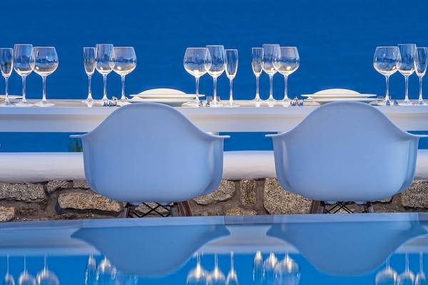 Außenbereich des DeLight Boutique Hotels mit Tisch und Stühlen am Pool.