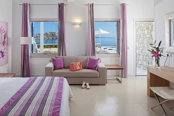 Schlafzimmer im DeLight Boutique Hotel mit Meerblick, Bett, Sofa, Fenstern und Dekor.