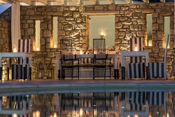 Außenbereich des DeLight Boutique Hotels mit Esstisch am Pool.