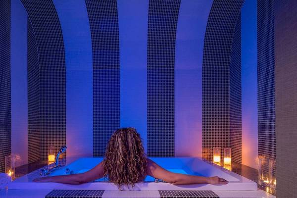 Eine Frau entspannt sich in der Whirlpool-Badewanne des DeLight Boutique Hotels.