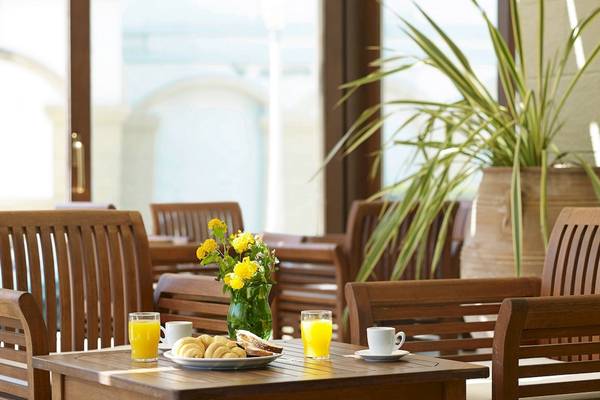 Frühstückstisch im Mitsis La Vita Beach Hotel mit Orangensaft, Croissants und Brot.