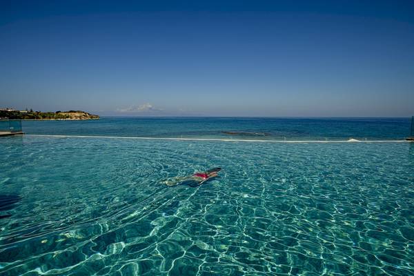 Person im Infinity-Pool des Alexandra Beach Resorts mit Blick auf das Meer