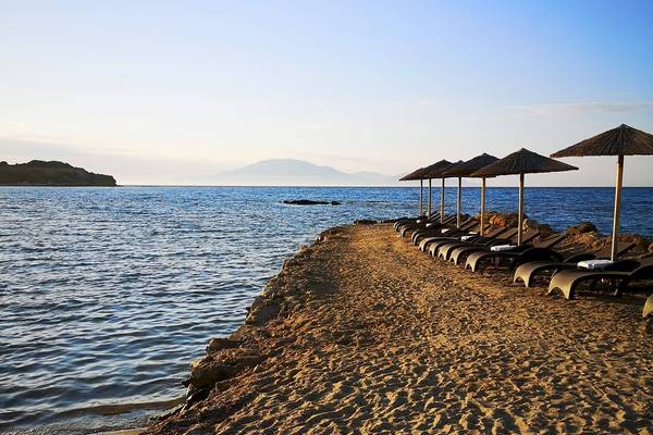 Strand des Alexandra Beach Resort & Spa mit Sonnenliegen und Sonnenschirmen am Meer