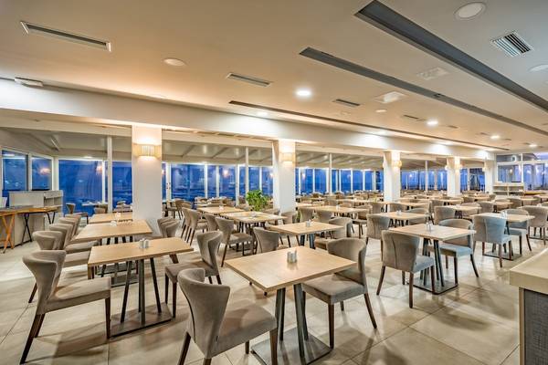 Innenansicht des Restaurants im Alexandra Beach Resort & Spa mit vielen Tischen und Stühlen.