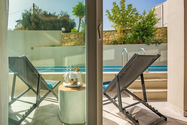 Terrasse mit Swimmingpool und Sonnenliegen im Alexandra Beach Resort & Spa