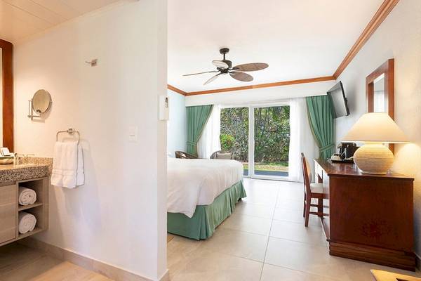 Innenansicht der Suite im Occidental Tamarindo Hotel mit Schlafzimmer und Badezimmer.