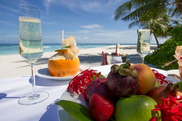 Fruechte und Secco auf einem Tisch am Strand des Dhawa Ihuru Hotels