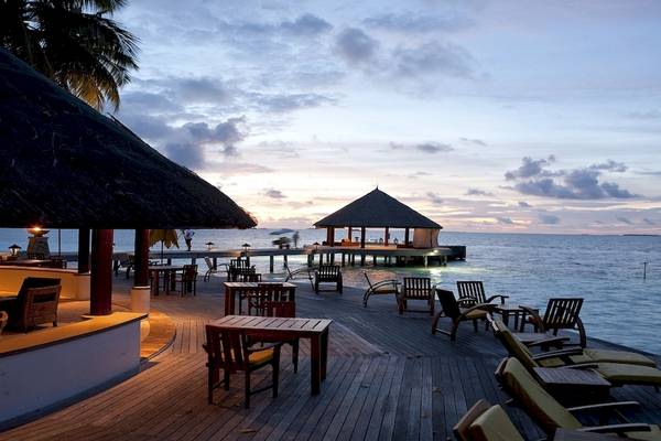 Dhawa Ihuru Hotel Terrasse bei Sonnenuntergang mit Blick auf das Meer.