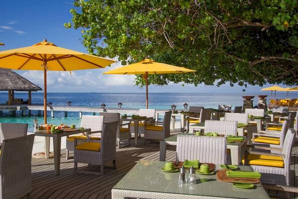 Terrasse des Dhawa Ihuru Hotels mit Sonnenschirmen und Blick auf das Meer