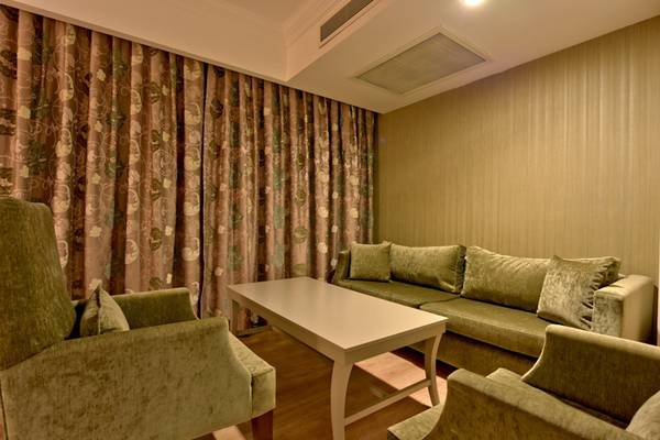 Wohnzimmer im Side Star Resort mit grünen Möbeln, einem Tisch und einem Sofa.