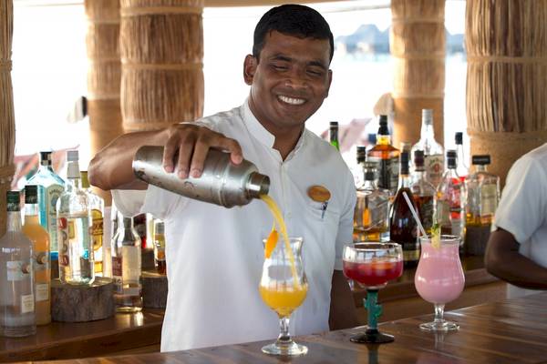 Ein Barkeeper des Coco Palm Dhuni Kolhu schenkt Cocktails in Gläser ein.