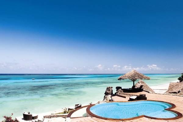 Außenpool am Strand des Karafuu Beach Resort & Spa mit Blick auf das Meer.